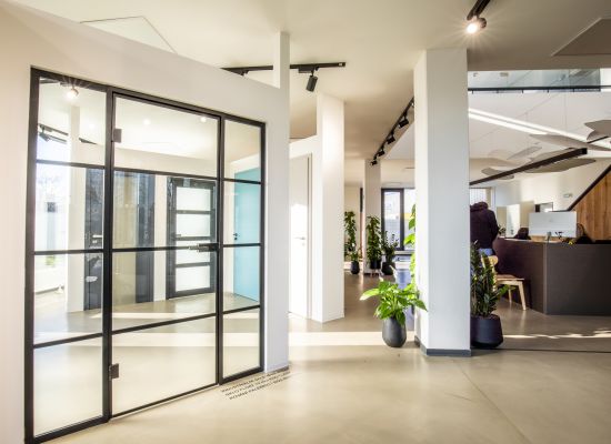 Kliknutím zvětšíte Detail skleněných dveří v kovovém rámu, showroom PRO-K a značky SAPELI.