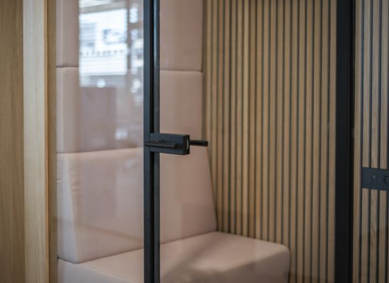 Kliknutím zvětšíte Telefonické budky na míru (phonebooty) - detail skleněných dveří s elegantním kováním v černém designu.